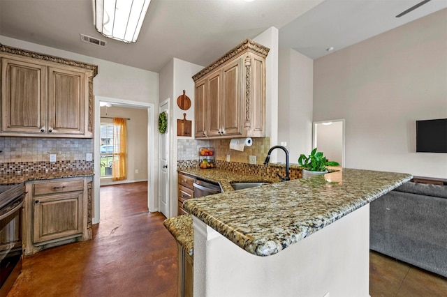 kitchen with visible vents, stone counters, a sink, open floor plan, and backsplash