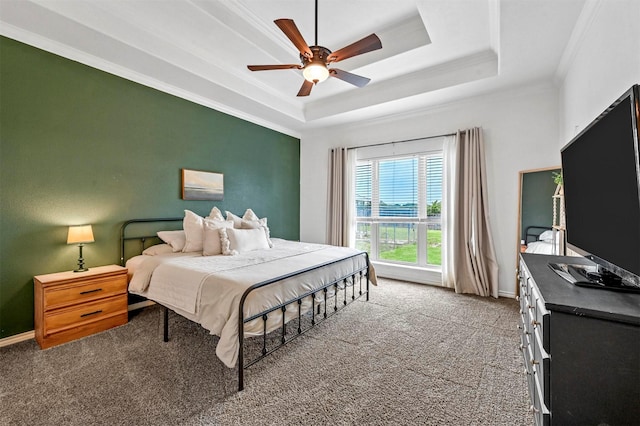 carpeted bedroom with crown molding, a ceiling fan, a raised ceiling, and baseboards