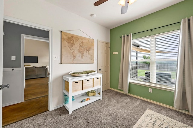 interior space featuring baseboards, ceiling fan, and carpet floors