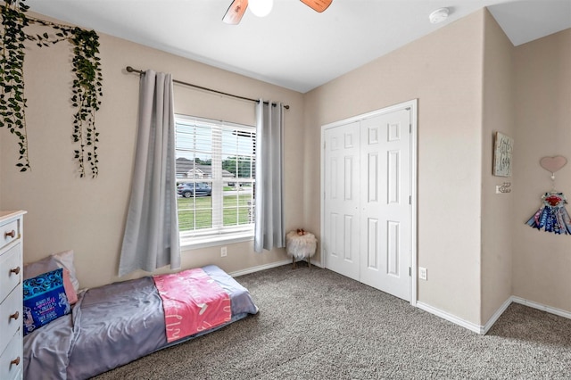 carpeted bedroom with a closet, ceiling fan, and baseboards