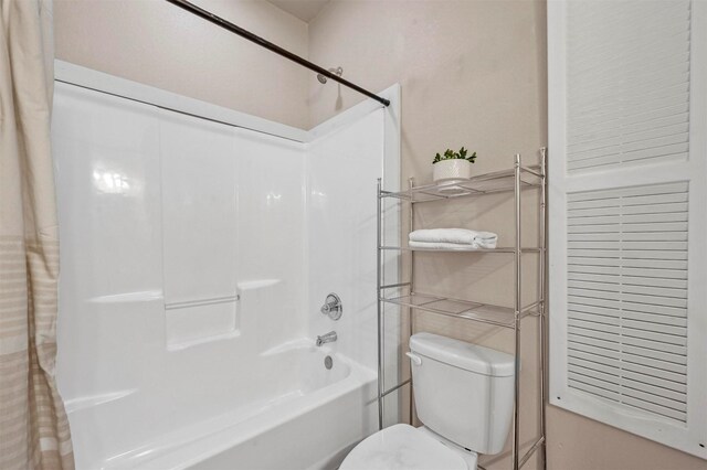 full bath with toilet and shower / bath combo with shower curtain