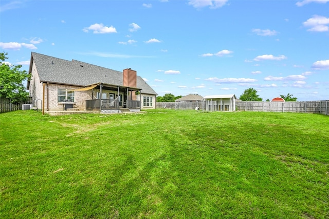 view of yard featuring central air condition unit, a wooden deck, and a fenced backyard