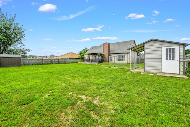 view of yard with a storage shed, a fenced backyard, and an outdoor structure