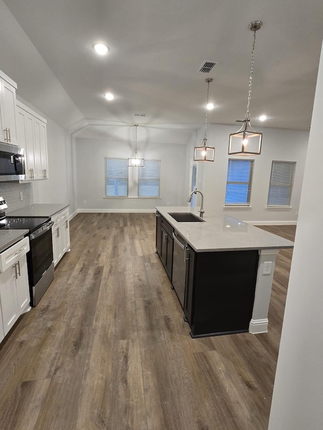 kitchen with white cabinetry, pendant lighting, stainless steel appliances, and a center island with sink