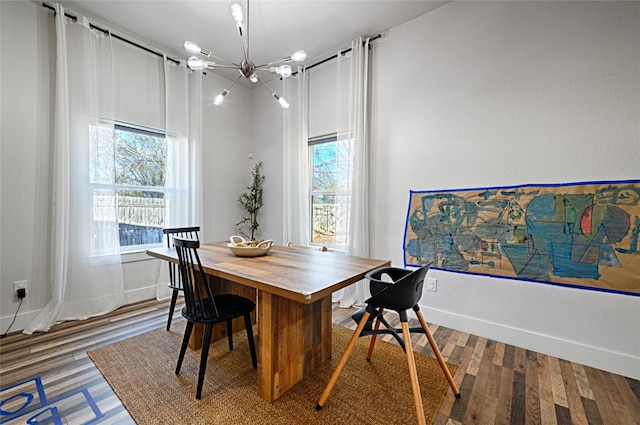 dining area with dark hardwood / wood-style floors, an inviting chandelier, and plenty of natural light