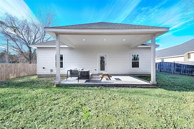 rear view of house with a lawn and a patio