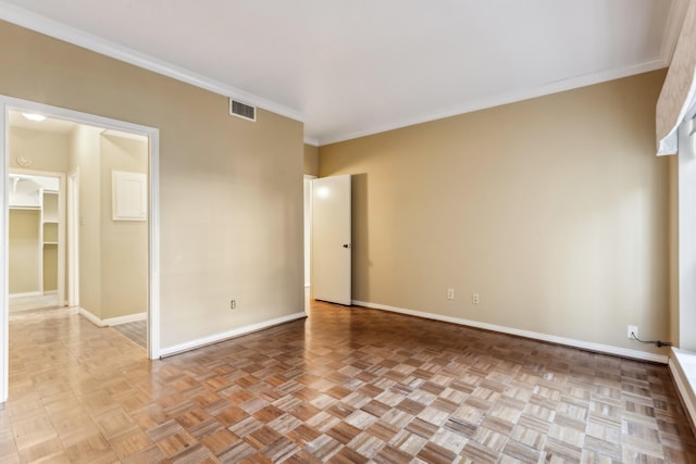 empty room featuring light parquet flooring and ornamental molding