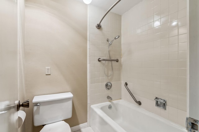 bathroom featuring toilet and tiled shower / bath