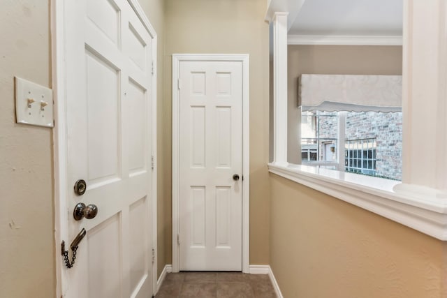 doorway to outside with tile patterned floors and ornamental molding