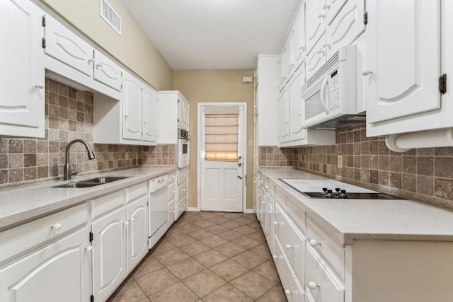 kitchen with sink, tasteful backsplash, light tile patterned flooring, white appliances, and white cabinets