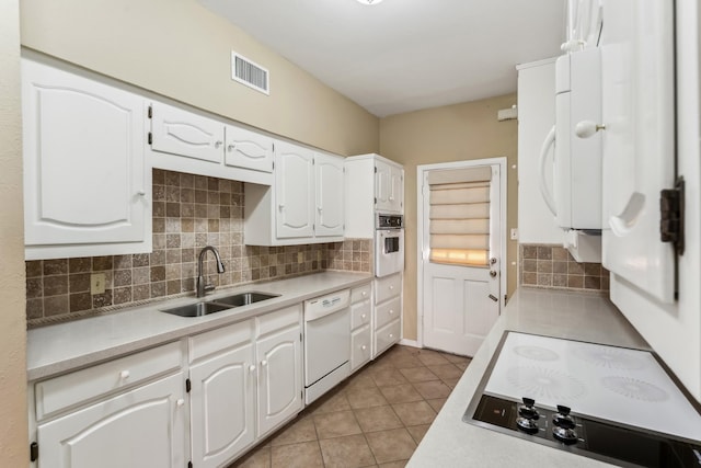 kitchen featuring white cabinets, light tile patterned floors, white appliances, and sink