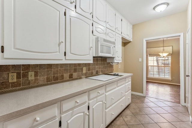 kitchen featuring tasteful backsplash, light tile patterned floors, white cabinets, and white appliances