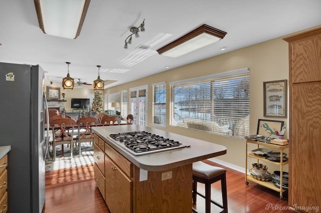 kitchen featuring dark hardwood / wood-style flooring, a center island, stainless steel appliances, and a healthy amount of sunlight