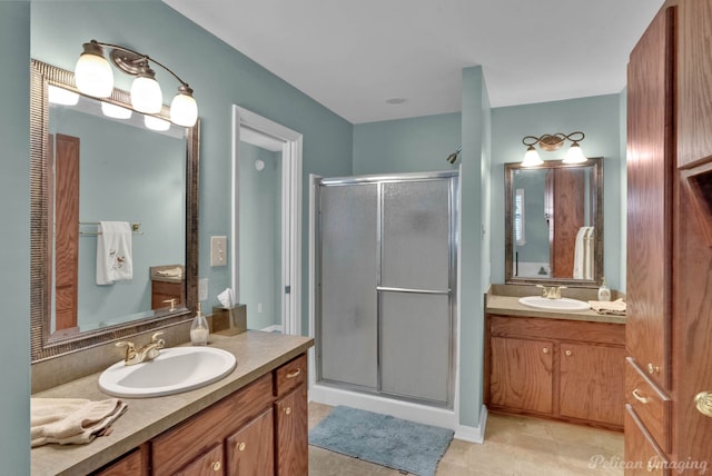 bathroom featuring tile patterned floors, vanity, and a shower with door