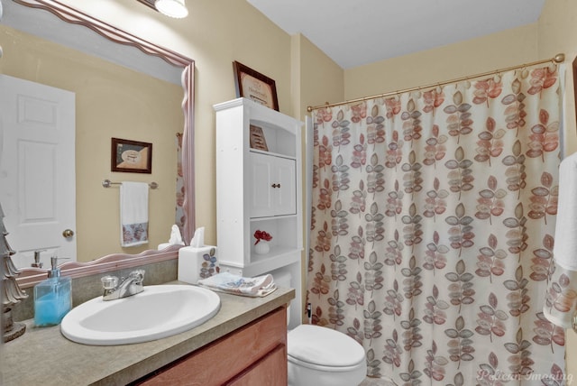 bathroom with a shower with shower curtain, vanity, and toilet