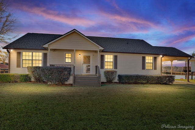 ranch-style home with covered porch and a yard