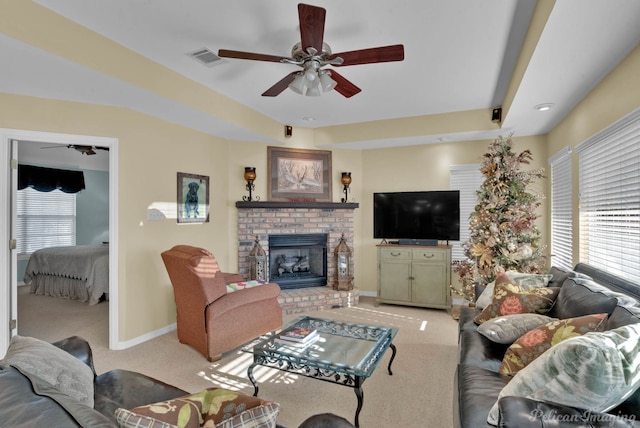 carpeted living room with ceiling fan, a fireplace, and a healthy amount of sunlight