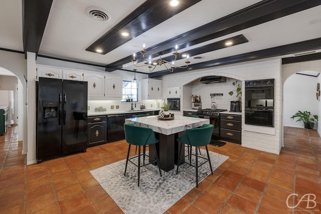 kitchen featuring black appliances, a kitchen breakfast bar, a kitchen island, decorative backsplash, and white cabinets