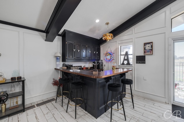 bar with crown molding, sink, and decorative light fixtures