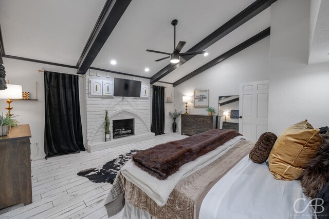 bedroom with a fireplace, lofted ceiling with beams, ceiling fan, and light wood-type flooring