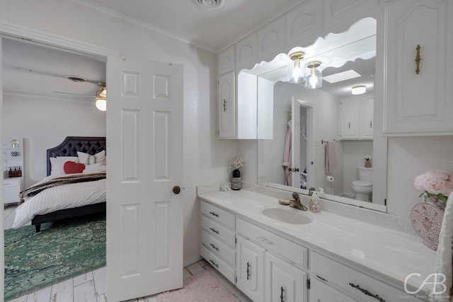 bathroom with vanity, ornamental molding, and toilet