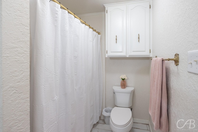 bathroom with ornamental molding and toilet