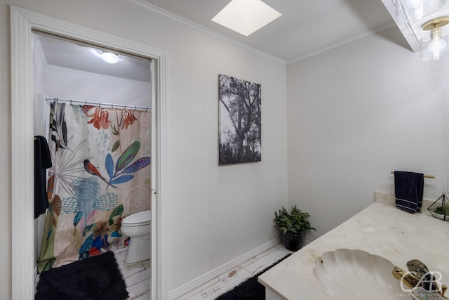 bathroom with vanity, a skylight, ornamental molding, and toilet