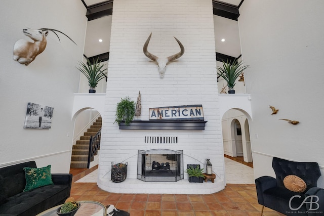 living room with tile patterned flooring, a brick fireplace, beam ceiling, and high vaulted ceiling