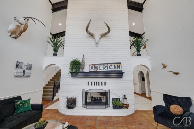 living room with a brick fireplace and a high ceiling