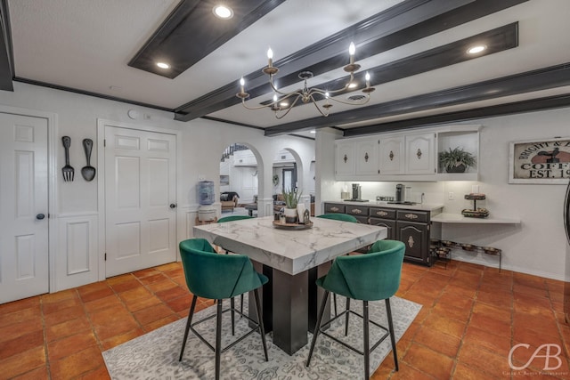 dining room featuring an inviting chandelier, beam ceiling, and ornamental molding