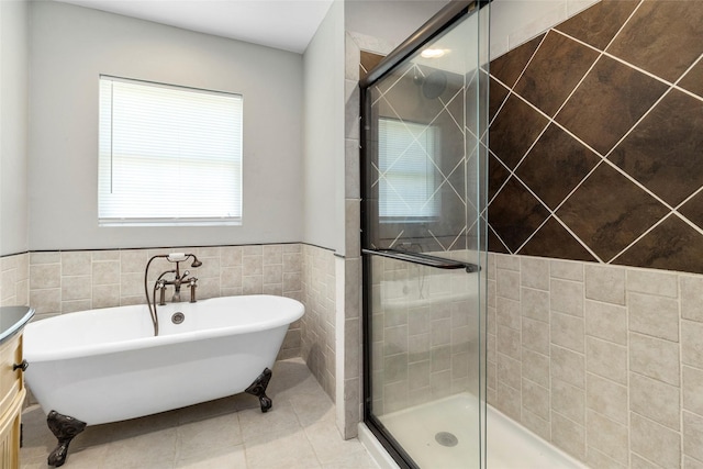 bathroom featuring tile patterned floors, vanity, separate shower and tub, and tile walls