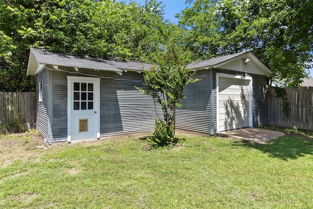 view of outdoor structure featuring a garage and a lawn