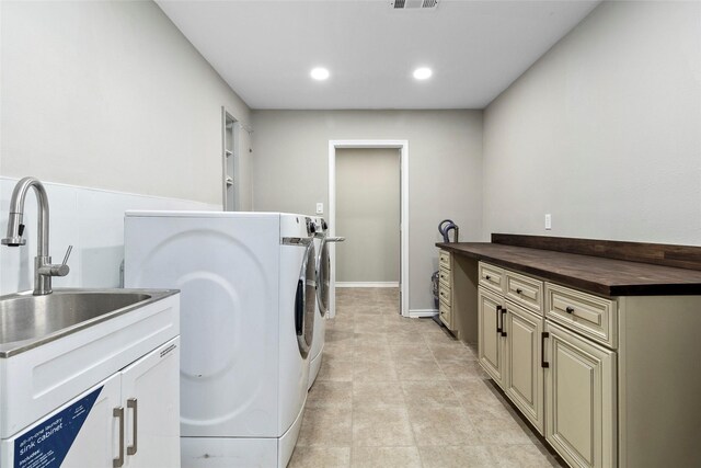 laundry area with washer and clothes dryer and cabinets