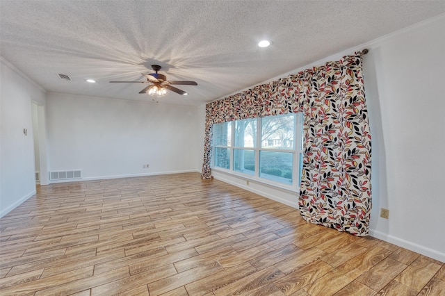 unfurnished room featuring ceiling fan, light hardwood / wood-style floors, ornamental molding, and a textured ceiling