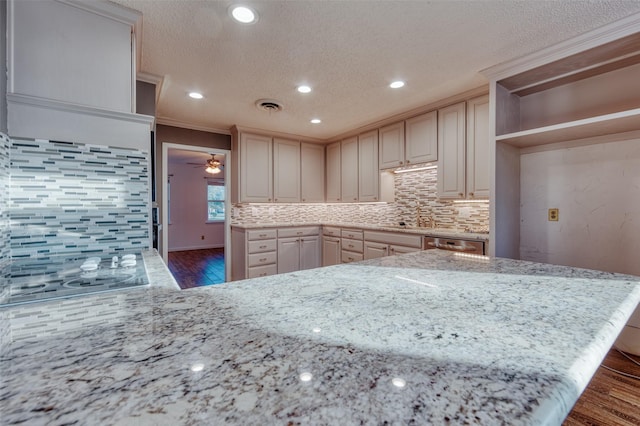 kitchen featuring dark hardwood / wood-style flooring, tasteful backsplash, light stone counters, and ornamental molding