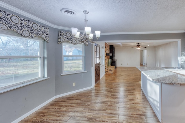 unfurnished dining area with a healthy amount of sunlight, ornamental molding, and a textured ceiling