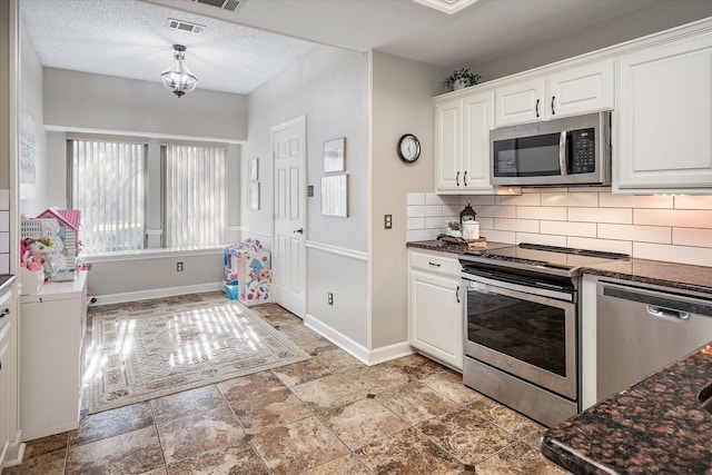 kitchen with tasteful backsplash, white cabinets, a textured ceiling, and appliances with stainless steel finishes