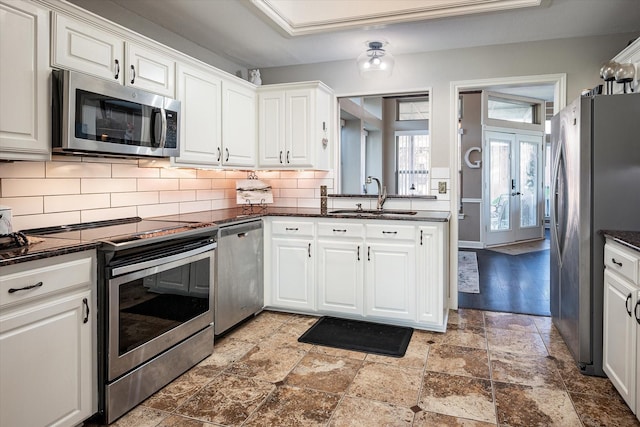 kitchen with backsplash, french doors, white cabinets, sink, and appliances with stainless steel finishes