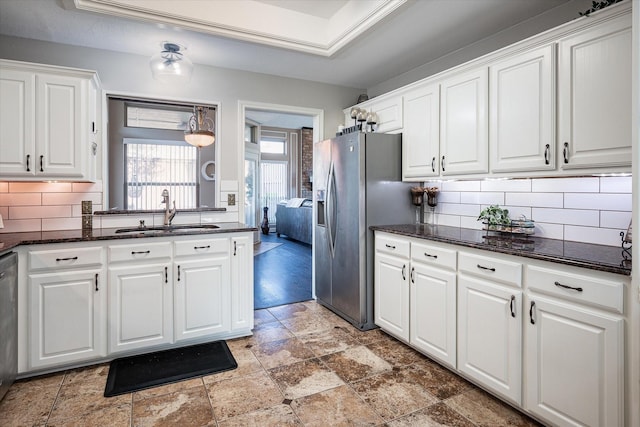 kitchen with white cabinetry, sink, decorative backsplash, and appliances with stainless steel finishes