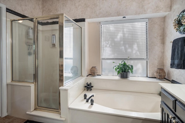 bathroom featuring independent shower and bath, vanity, and a healthy amount of sunlight