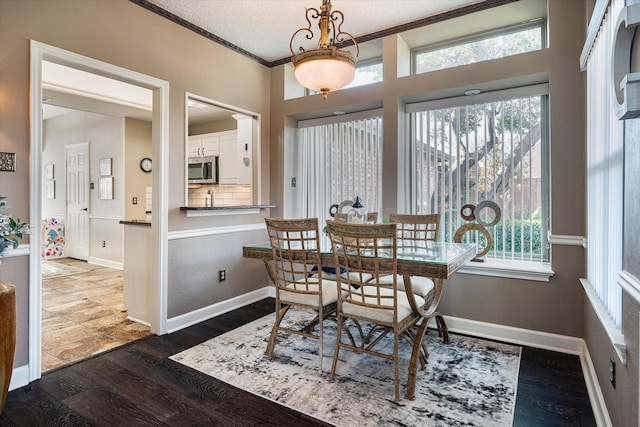 dining space with a textured ceiling, dark hardwood / wood-style floors, and crown molding