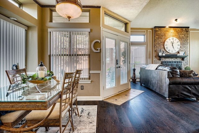 dining space with dark hardwood / wood-style floors, a wealth of natural light, and a textured ceiling