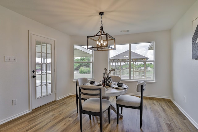 dining space with a notable chandelier and wood-type flooring