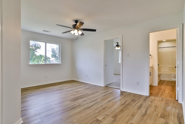 unfurnished bedroom featuring light wood-type flooring, ensuite bathroom, and ceiling fan