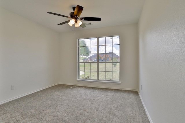 carpeted spare room featuring ceiling fan and a healthy amount of sunlight