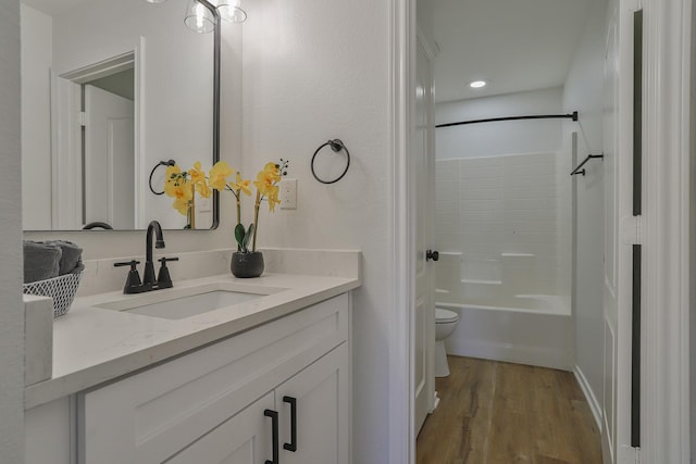 full bathroom with hardwood / wood-style flooring, vanity, toilet, and shower / washtub combination