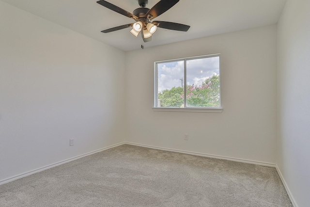 spare room featuring light carpet and ceiling fan