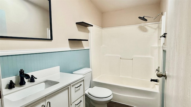 full bath featuring vanity, toilet, shower / bathtub combination, and wainscoting