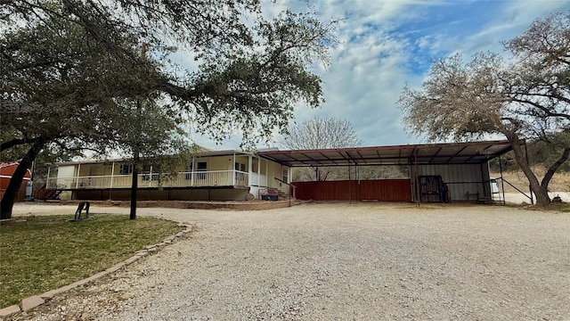 view of front of property with a carport and gravel driveway