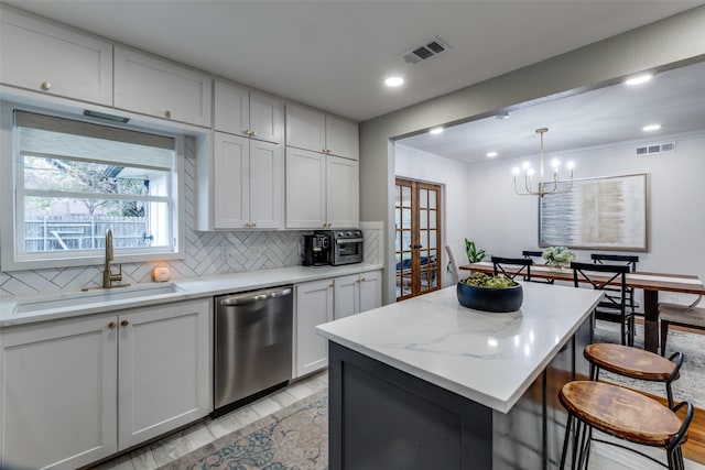 kitchen with sink, white cabinetry, a center island, hanging light fixtures, and dishwasher